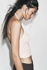 Top corto de cuello halter con diseño seamless, espalda descubierta y bajo recto.