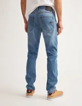 Pantalón de jean celeste, corte slim fit, con bolsillos delanteros y traseros.