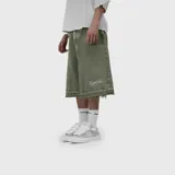 Bermuda baggy de denim color verde militar, de corte ancho y largo hasta las rodillas. Presenta bordado en hilo blanco en la pierna izquierda y terminación deshilachada en el bajo.