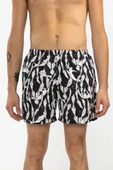 Short de baño negro con estampado de sirenas blancas y plantas marinas.