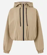 Campera cortavientos de color beige con diseño balonê, capucha con cordones ajustables, cierre frontal de cremallera y puños con elástico. Presenta un corte holgado y moderno.