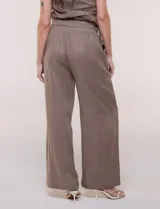 Conjunto de dos piezas de lino verde oscuro, compuesto por un top de un solo hombro con arandela decorativa y un pantalón palazzo de tiro alto con cintura elástica y bolsillos.