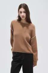 Sweater de algodón color natural, de corte holgado y cuello redondo. Presenta detalles de costuras decorativas con bordado en los hombros y puños acanalados.