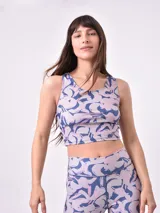 Top deportivo corto estampado con flores abstractas en tonos azul, lila y rosa. Diseño de espalda deportiva.