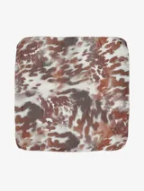 Pañuelo cuadrado de tela liviana con estampado multicolor en tonos marrones, blancos y naranjas con patrones geométricos y abstractos.