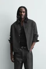 Sobrecamisa boxy fit de hombre confeccionada en tejido efecto ante color beige, con cuello solapa, manga larga con puño abotonado, bolsillo de parche en el pecho y cierre frontal con botones a presión ocultos.