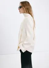 Blazer Martin de diseño recto y color beige, con cuello en pico, sin solapa, manga larga y bolsillos frontales de parche. Incluye forro interior.