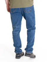 Jeans de corte slim en denim azul con efecto lavado, cierre de cremallera y botón, diseño de cinco bolsillos y detalles de la marca CAT.