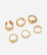 Set de seis anillos de metal en tono dorado con diseños orgánicos, formas irregulares y acabados texturizados.