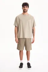 Remera oversize verde de manga corta y cuello redondo, con pequeño estampado gráfico en el pecho con la inscripción "Sixty Nine".
