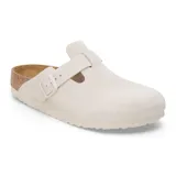 Zueco tipo mule de gamuza en color blanco, con diseño de punta cerrada, tira ajustable con hebilla lateral y plantilla anatómica de corcho.
