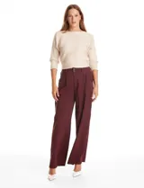 Pantalón tipo palazzo de corte ancho y fluido, confeccionado en tejido sastrero. Presenta tiro alto con doble abotonadura frontal, pinzas decorativas y cintura elástica en la parte posterior. Incluye bolsillos laterales funcionales.