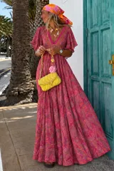 Vestido largo verde con estampado paisley, escote en V profundo, mangas amplias con volados y corte imperio con detalles bordados.