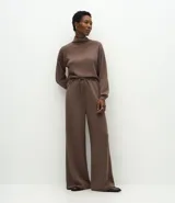 Pantalón de corte recto y tiro alto, color marrón, con cintura elástica ajustable mediante lazo frontal. Presenta un diseño fluido y cómodo.