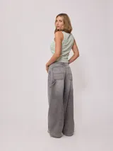 Jean de corte baggy y tiro medio, confeccionado en denim de algodón en tono azul claro con efecto lavado. Presenta diseño de cinco bolsillos, cierre frontal con botón y cremallera, y pernera ancha.