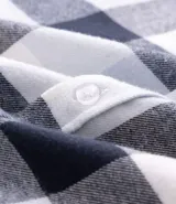 Camisa de corte comfort confeccionada en algodón, con estampado de cuadros en tonos marrón, beige y azul. Presenta cuello camisero, mangas largas con puños abotonados y cierre frontal con botones.