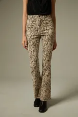 Pantalon de jean con corte flare y tiro alto, estampado con diseño animal print de leopardo en tonos marrones. Cuenta con bolsillos funcionales y ruedo desflecado.