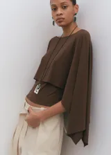 Blusa marrón de corte recto, con cuello redondo y mangas tres cuartos amplias.