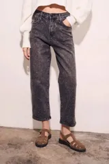 Jean de tiro alto, corte recto y largo al tobillo, en color negro lavado con apliques de strass o brillos distribuidos por toda la prenda.