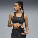 Top deportivo Puma modelo 4Keeps con diseño de espalda nadadora, confeccionado en tejido elástico con estampado animal print en tonos grises y negros. Presenta el logo de la marca estampado en el frente.