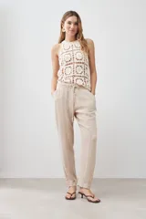 Pantalón de pijama de lino color beige melange, con cintura elástica ajustable con cordón y pespuntes en contraste.