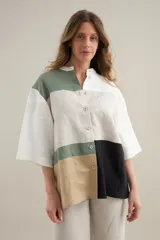 Camisa de lino de calce relajado, con cuello mao, mangas cortas y un diseño de bloques de color en tonos blanco, verde militar, tostado y negro. Cuenta con cierre frontal de botones.