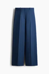Pantalón sastrero de tiro alto y perneras amplias en color azul, con pinzas delanteras y traseras marcadas, y trabillas para cinturón.
