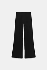 Pantalón largo negro de tiro alto, confeccionado en tejido elástico, con cintura elástica y diseño de pierna ancha tipo palazzo con bajo evasé.