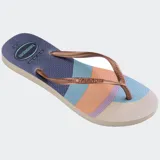 Ojotas Havaianas Slim Palette Glow con base estampada en tonos rosa, naranja y marrón, tiras finas color cobre y logo de la marca en las tiras.