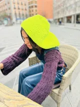 Buzo corto tejido a crochet en lana color marrón oscuro, con capucha.