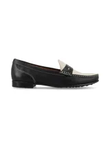 Mocasín de cuero estilo bicolores en negro y marfil, con costuras visibles a contratono y suela de goma.