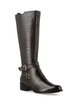 Bota de caña alta color marrón, con taco medio, capellada en cuero napa y caña en cuero croco. Presenta hebilla y apliques metálicos decorativos, panel trasero elastizado y cierre interior.