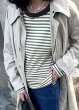 Remera de manga larga a rayas horizontales color verde y beige, con cuello redondo marrón en contraste y aberturas laterales.