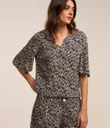 Blusa de viscosa con estampado de follaje en blanco y negro, escote en V y mangas cortas.