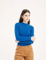 Polera negra de tejido de punto acanalado, con cuello alto y mangas largas.