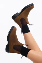 Botas de cuero marrón con elásticos laterales y suela negra.