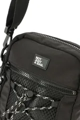Morral negro de diseño compacto con compartimento principal con cierre, bolsillo frontal de malla con cordón elástico ajustable y parche con texto. Incluye correa regulable y extraíble.
