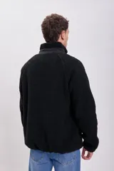 Campera de sherpa color negro con cierre frontal, cuello alto y bolsillo frontal con cierre en contraste.