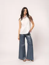 Blusa blanca sin mangas, con cuello alto con volados y detalles bordados con motivos florales.