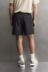 Pantalón corto deportivo de Zara Athleticz confeccionado en tejido técnico ligero y elástico de color negro. Cuenta con cintura elástica ajustable con cordón, bolsillos frontales y aberturas laterales en el bajo.