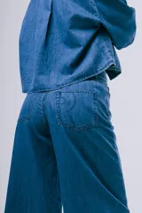 Pantalón wideleg de denim azul oscuro, de tiro alto y corte amplio con bolsillos laterales y cinturón incorporado.