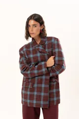 Blazer de corte oversize con estampado de cuadros en tonos azul, bordó y marrón. Presenta solapas clásicas, bolsillos con solapa en el frente y cierre frontal con botones.