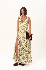 Vestido largo de tela sedosa con estampado abstracto en tonos verde oliva, blanco y negro. Presenta escote en V profundo, tirantes anchos y tajos laterales pronunciados en la falda.