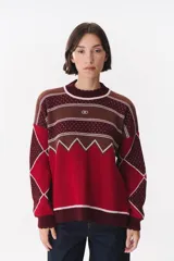 Buzo de tejido de punto con diseño geométrico y combinación de colores en contraste. Presenta cuello redondo, mangas largas y corte oversized.