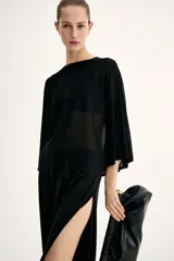 Top negro de punto transparente, con corte holgado, mangas murciélago tres cuartos, escote redondo y bajo recto.