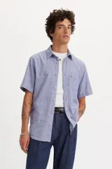 Camisa de manga corta Levi's en color azul con textura tipo chambray. Presenta cuello clásico, cierre frontal con botones y un bolsillo en el pecho con la etiqueta roja característica de la marca.