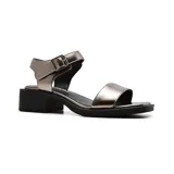 Sandalias blancas de cuero con dos tiras, una sobre los dedos y otra al tobillo con hebilla metálica. Taco bajo de madera.