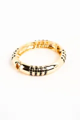 Brazalete rígido dorado con incrustaciones de strass negro en secciones de la pieza.