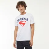 Camiseta blanca de manga corta con estampado del logo de Superman en rojo y el nombre del superhéroe en azul.