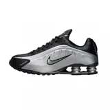 Championes Nike Shox R4 de diseño técnico en color negro total. Presentan la icónica tecnología de amortiguación Shox en el talón, con una estructura de columnas que proporciona soporte y respuesta. El exterior combina cuero sintético con paneles perforados para mayor ventilación y un acabado elegante.
